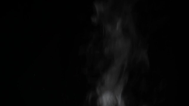 White smoke rising from below against a black studio backdrop, horizontal composition
