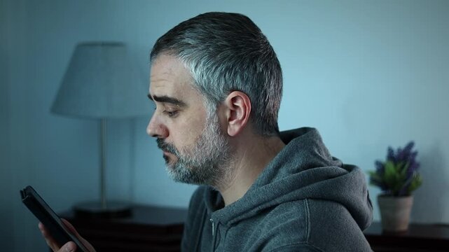 Lonely mature man feeling hopeless, watch phone, lays down