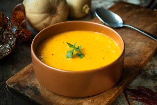 Bowl of cream pumpkin soup. Tradition autumn food. Thanksgiving dinner in rustic style