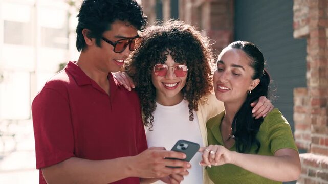Video of three friends using smartphone while having fun in the street