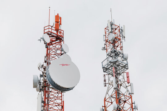 June 2, 2026, Tornik, Serbia: Two Tall Telecommunication Towers with Satellite Dishes Against Overcast Sky. Technology concept.
