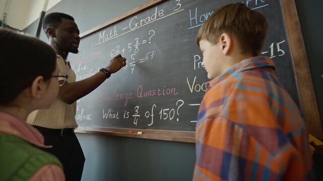 African American male teacher explaining math equations on African Americanboard to diverse elementary school children. Video is suitable for promoting tutoring services and primary education programs