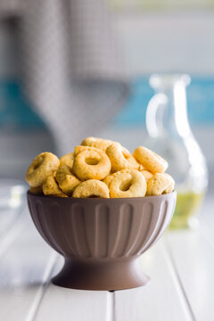 Bowl of Savory Taralli Ring Snacks on White Table with Olive Oil and Rustic Cloth