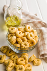 Naklejka na ściany i meble Taralli Italian Crackers With Olive Oil in Bowl On Kitchen Table Rustic Savory Snack