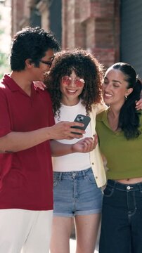 Video of three friends using smartphone while having fun in the street