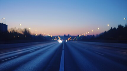 Obraz premium Blurred highway at dusk with light trails and bokeh headlights, urban road perspective with motion blur