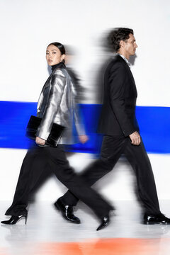 Fashionable couple walking past each other with motion blur
