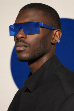 Stylish Black man wearing futuristic blue visor sunglasses