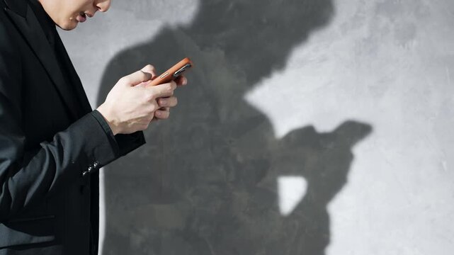 スマホを使う男性とシルエット。悩む, トラブル, 問題, 焦る, 困る, 疑問, シリアス, 犯罪