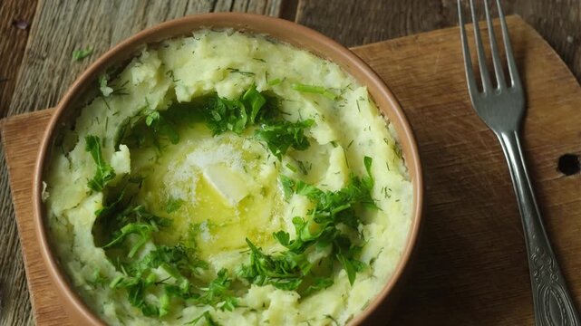 Bowl of mashed potatoes with fresh herbs and butter. Thanksgiving meal.