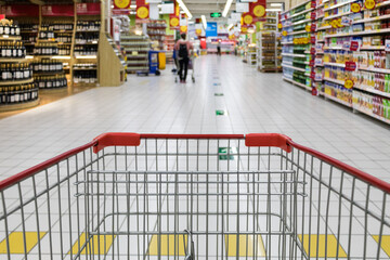 Shopping cart view in supermarket aisle with grocery shelves © PhamHong