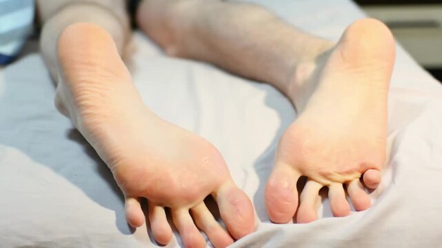 Bare feet soles relaxed on bed after long day of activity