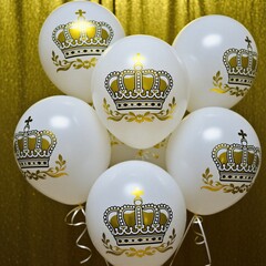 Obraz premium White balloons with gold crowns float indoors. Festive decor features royal imagery for parties, celebrations, and elegant events. Luxurious party decorations.