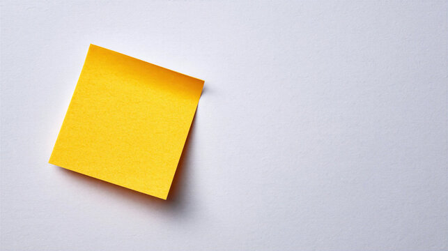Yellow sticky note on white paper background with soft shadow and clean space