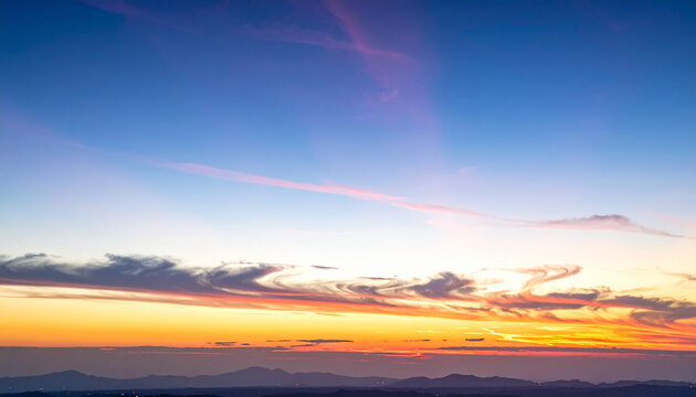 Peaceful Sunset Sky Over Distant Mountains
