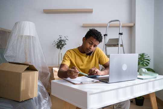 Man organizing documents with calculator at home working at desk