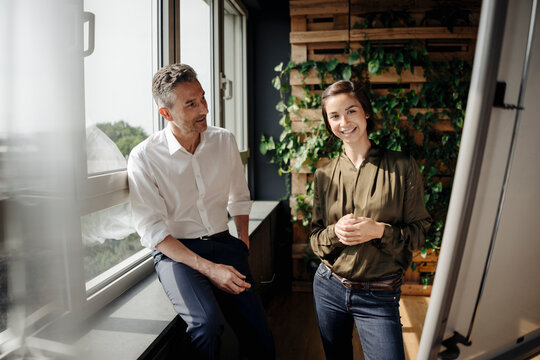 Businessman and businesswoman working with flip chart in green office
