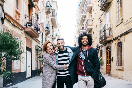 Three happy friends walking in the city
