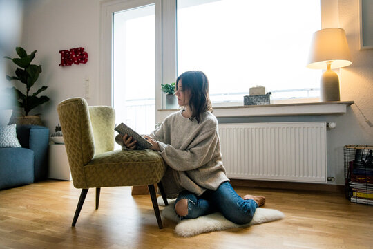 Woman sitting on floor, journalising in her diary