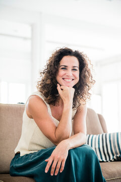 Confident woman sitting on her couch, smiling