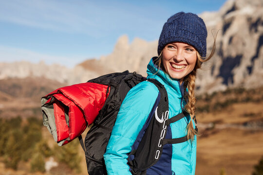 Portrait of happy young woman hiking in the mountains