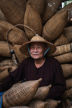 Artisan with bamboo fish traps in Hanoi Vietnam showing traditional craft