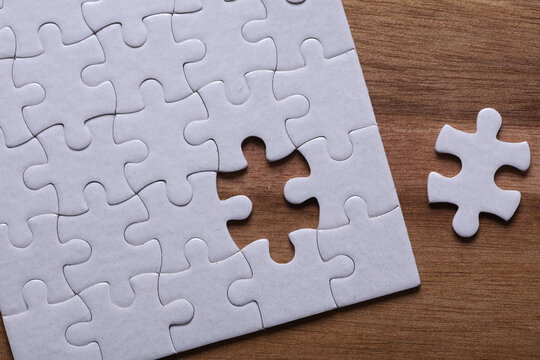 White blank puzzle on a wooden tray