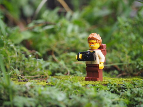 Indonesia - May 14, 2022 : Mini toy of action figure at grassland with blurred background. Toy photography concept. Adventure man concept design.