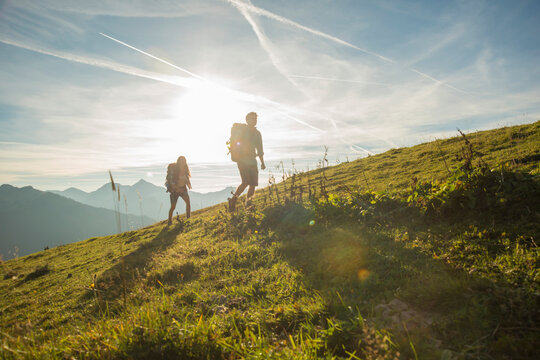 Austria, Tyrol, Tannheimer Tal, young couple hiking on alpine meadow