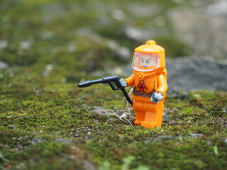 Fototapeta premium Indonesia - April 14, 2022 : Mini toy of action figure at table with blurred. Toy photography concept. Hazmat suit at outdoor conceptual design.