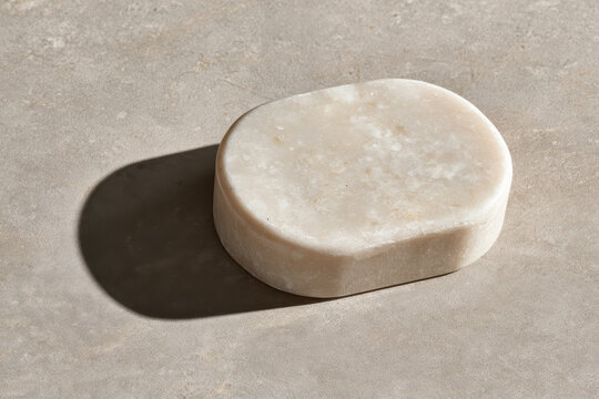 An eye-catching sculptural stone object with smooth edges rests on a neutral surface, exemplifying artistic minimalism while inviting a sense of tranquility and aesthetic appreciation.