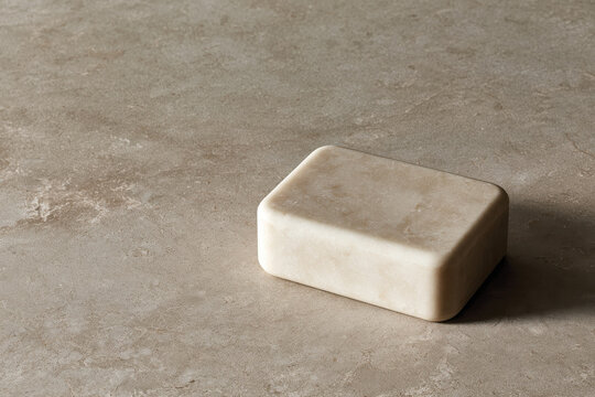 A beautifully crafted natural stone soap rests on an earthy textured surface, emphasizing simplicity and elegance, ideal for minimalistic aesthetics and wellness themes.