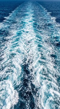 High Angle View of Symmetric Ship Wake in Open Ocean with Shimmering Turquoise Ripples and Long Thick White Sea Foam Texture Background