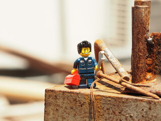 Fototapeta premium Indonesia - January 19, 2020 : Mini toy of action figure at table with blurred. Toy photography concept. Mechanical engineer conceptual design. Worker at site project with wrench tool.