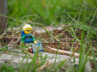 Fototapeta premium Indonesia - November 27, 2019 : Mini toy of action figure at grassland with blurred background. Toy photography concept. Adventure man at grass land conceptual design.