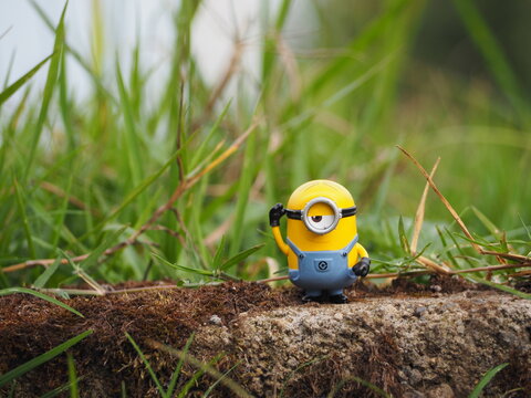 Indonesia - November 11, 2019 : Mini toy of action figure at outdoor with blurred background. Toy photography concept design. Minifigure of Minions character from Despicable Me cartoon film at garden.