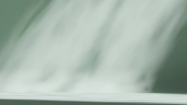 a video footage of poster design on a bare, understated setting with light green color for background
