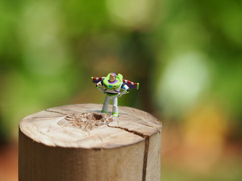 Indonesia - October 23, 2024 : Mini toy of action figure at outdoor with blurred background. Minifigure photography concept design. Flying Buzz Lightyear character from Toys Story film.