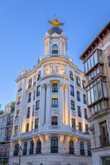 Fototapeta premium Elegant historic architecture with ornate dome and golden winged sculpture at blue hour in Valladolid, Spain