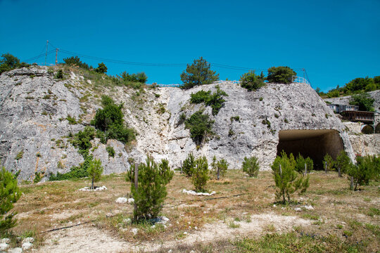 Tunnel entrance in limestone mountain on a clear sunny day. Mining technology and hydrology.