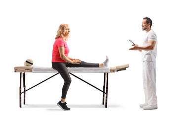 Obraz premium Physiotherapist talking to a female patient on a massage table