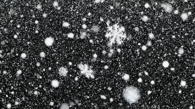 Superposici&oacute;n de copos de nieve blancos cayendo sobre fondo negro con efecto bokeh. Ideal para composiciones navide&ntilde;as, videos invernales, efectos visuales y motion graphics.