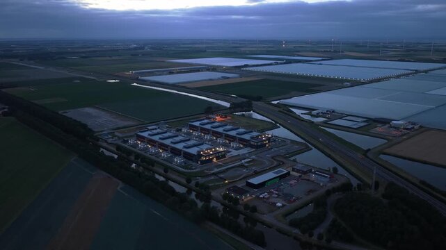 Aerial perspective of a modern hyperscale data center during the blue hour. The facility powers cloud computing and ai technology