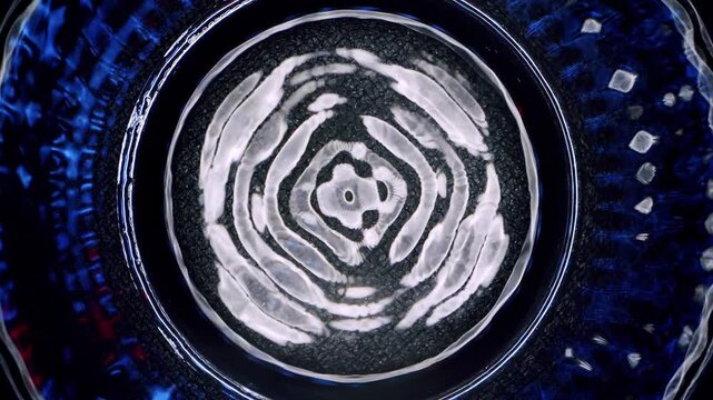 Close-up of intricate geometric wave patterns creating cymatic structures on a vibrating water surface. Concept of physics, harmony, frequency, and sound resonance.