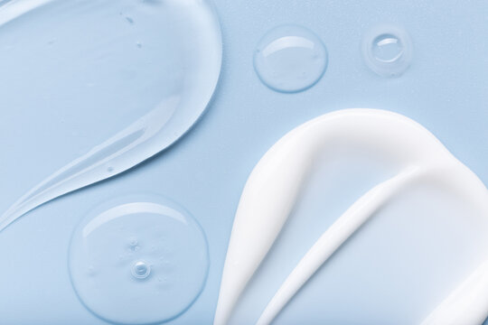 samples of cosmetic care products smear of cream and gel texture on a light blue background