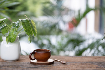 Wooden cup and spoon with philodendron plant on old wooden table © paladin1212