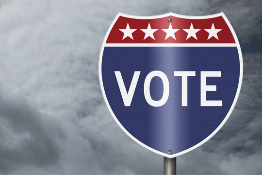 Vote text on an American interstate road sign with stormy sky for voting