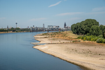 Niedrigwasser am Rhein mit Kölner Skyline und trockenem Ufer – Köln, Nordrhein-Westfalen, Deutschland © M. Claushallmann