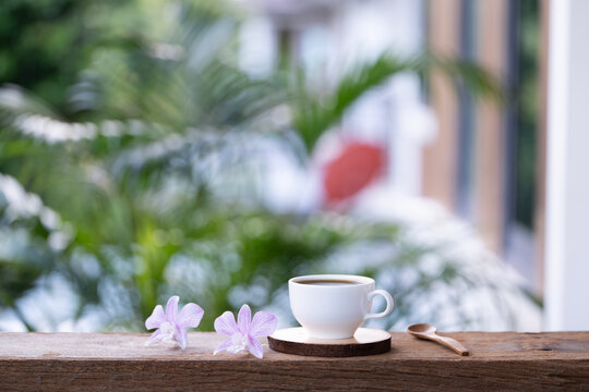 White ceramic cup and wooden spoon and purple orchid flowers