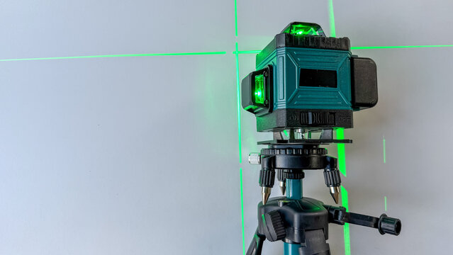 Close up of a laser level projecting crossing green lines for construction work.